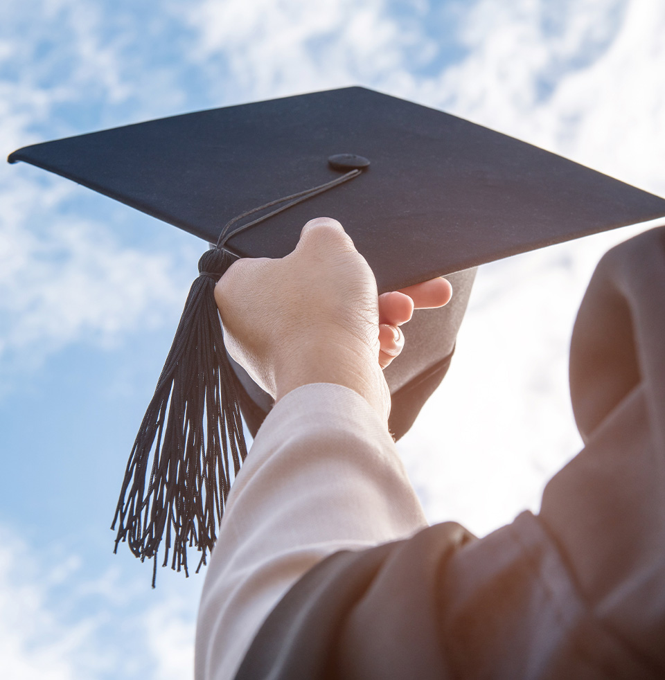 a person holding a graduation cap
